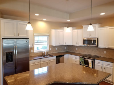 Warm white cabinet repaint in a finished kitchen